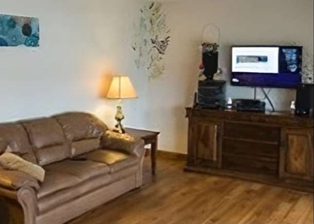 brown sofa and flat screen television in a residential setting sitting room